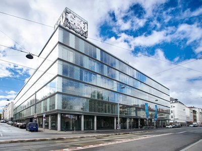 Ein Foto einer Straße und eines Gebäudes mit dem Schriftzug "CEU" auf dem Dach. 