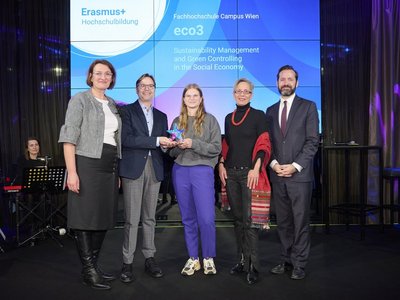 Fünf Personen stehen auf der Bühne, dahinter auf dem Screen der Schriftzug „Erasmus+ Hochschulbildung - Fachhochschule Campus Wien – eco3“