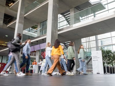 Personen, die durch eine Eingangshalle gehen.