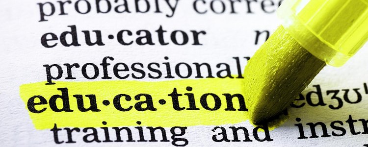 The picture shows an open dictionary, the word "education" is underlined by a yellow marker.