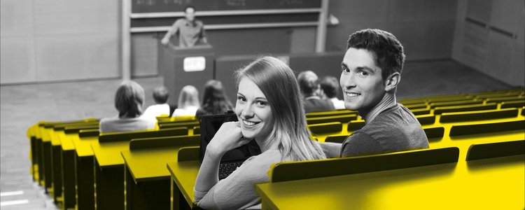 A student and a student are sitting in the lecture hall and laughing at the camera.