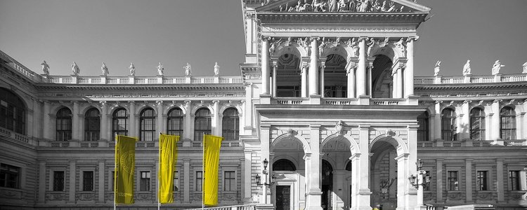Außenansicht des Haupgebäudes der Universität Wien mit Flaggen