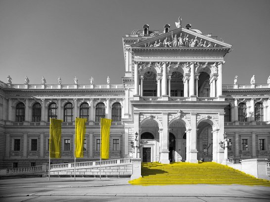 Außenansicht des Haupgebäudes der Universität Wien mit Flaggen