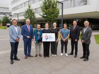 Students and representatives of FH St. Pölten hold a sign saying "Global Student Satisfaction Award"